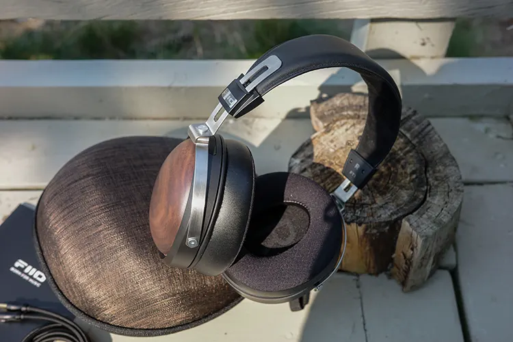 FiiO FT1 headphones on a log outdoors