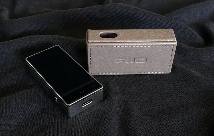 FiiO QX13 beside its grey leather case