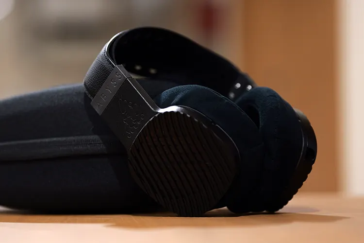 ABYSS JOAL headphones on the side of their case on a wooden bench