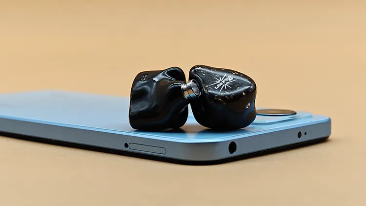 Kiwi Ears Astral shells on top of blue smartphone