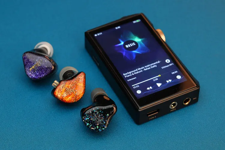 Hidizs x Linsoul AP80 PRO MAX DAP beside 3 earphone shells