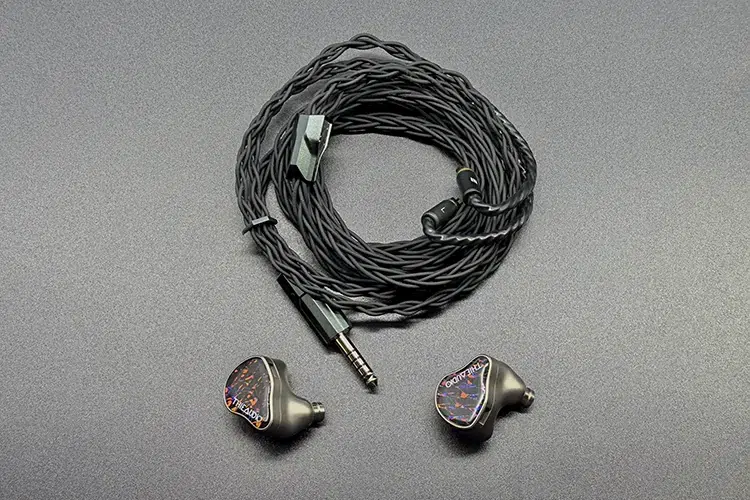 Effect Audio DIONYSUS cable rolled up above 2 IEM shells