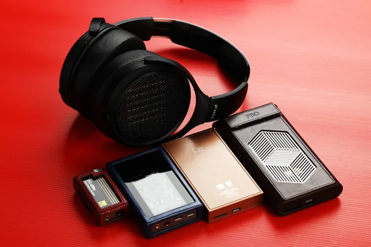 FiiO JT7 headphones beside dongles and a DAP