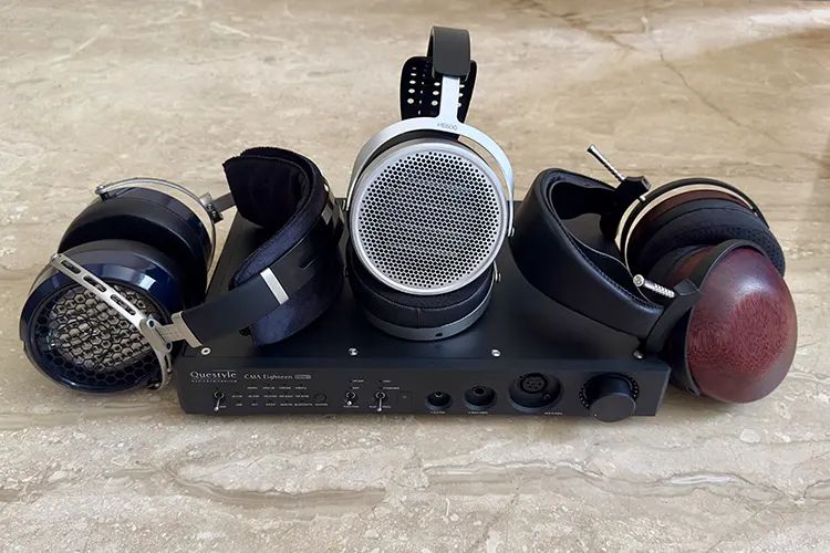 HIFIMAN HE600 and 2 other headphones beside a Questyle CMA-18M amplifier
