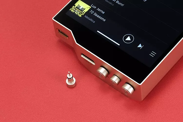 HiBy RS8 II port plugs with one spare beside the base of the DAP