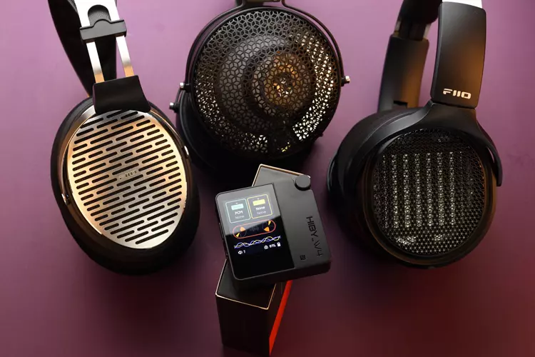 HiBy W4 beside 3 headphones