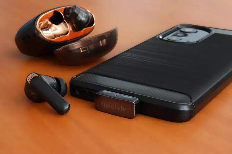 Questyle QCC Dongle Pro beside a smartphone and TWS