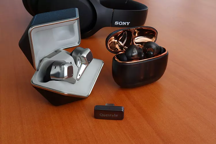 Questyle QCC Dongle Pro beside two TWS units