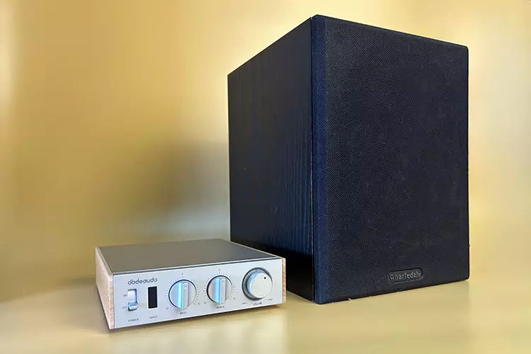 FiiO Jade Audio Level 1 amplifier beside a speaker