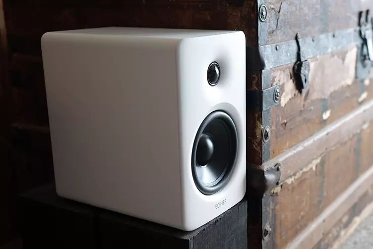 Edifier M90 left speaker beside a wooden chest