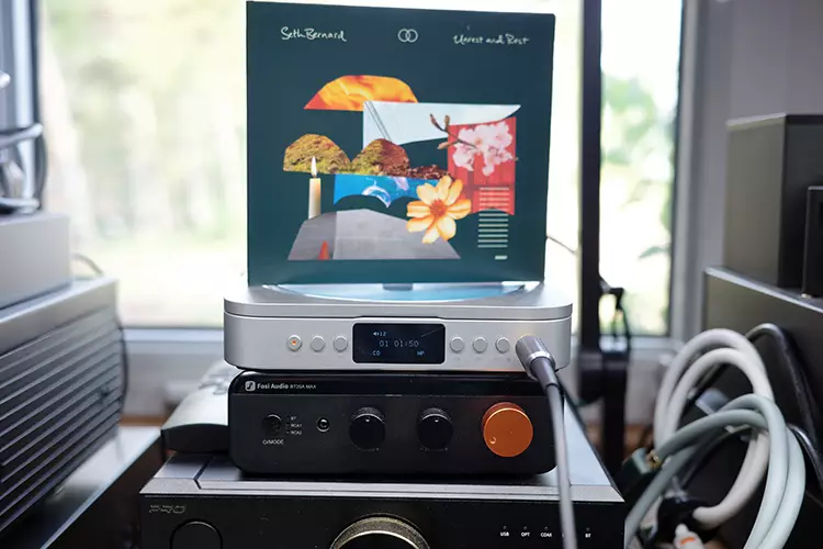 Fosi Audio Merak on top of the BTA20 MAX with a CD case
