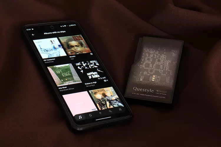 Questyle M18i Max beside a smartphone