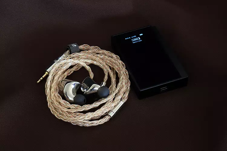 Questyle M18i Max beside an IEM